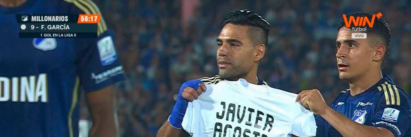 Radamel Falcao (izq) García y Daniel Cataño sostienen una camiseta estampada con la dedicatoria a Javier Acosta. / FOTO: CAPTURA DE VIDEO.