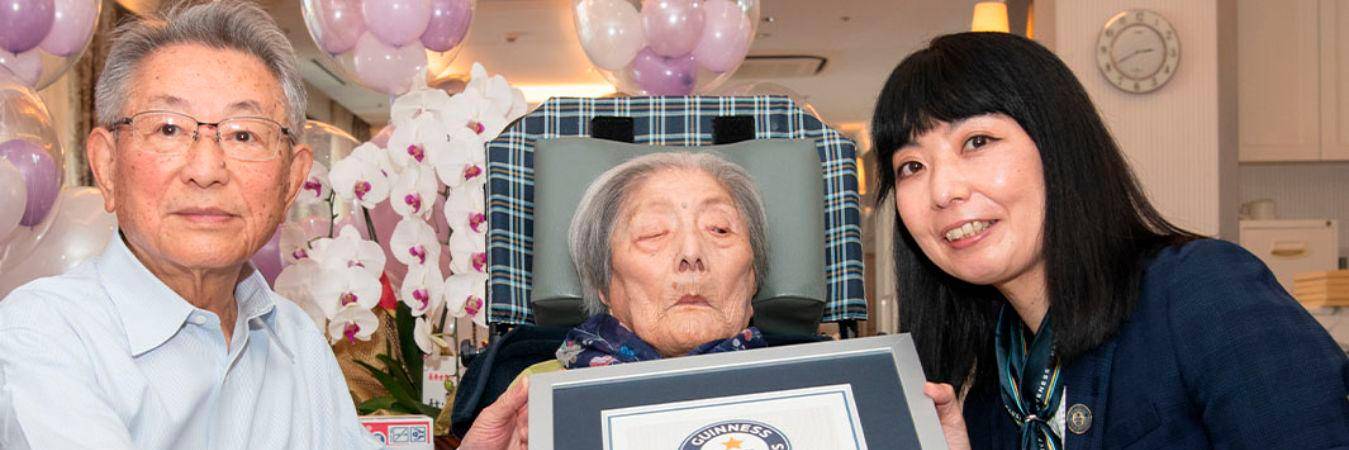 Tomiko Itooka (centro) con uno de sus hijos (izquierda) y la representante de los Récords Guinnes. / FOTO: RÉCORDS GUINESS