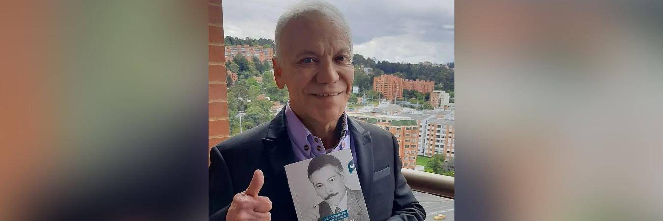 Juan Guillermo Ríos con el libro que escribió. FOTO: @OIRADIOTV 