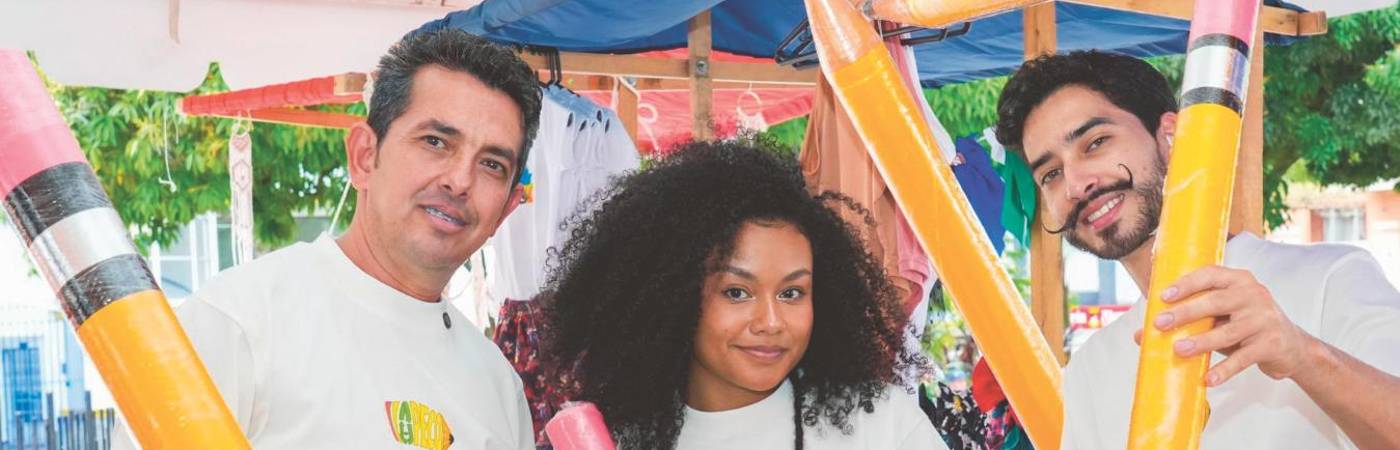 De izquierda a derecha: José; su nuera, Darlin; y su hijo, Deinner, quienes participan en la elaboración y comercialización del lápiz gigante, que también sirve de alcancía. FOTO: CORTESÍA LA PECO