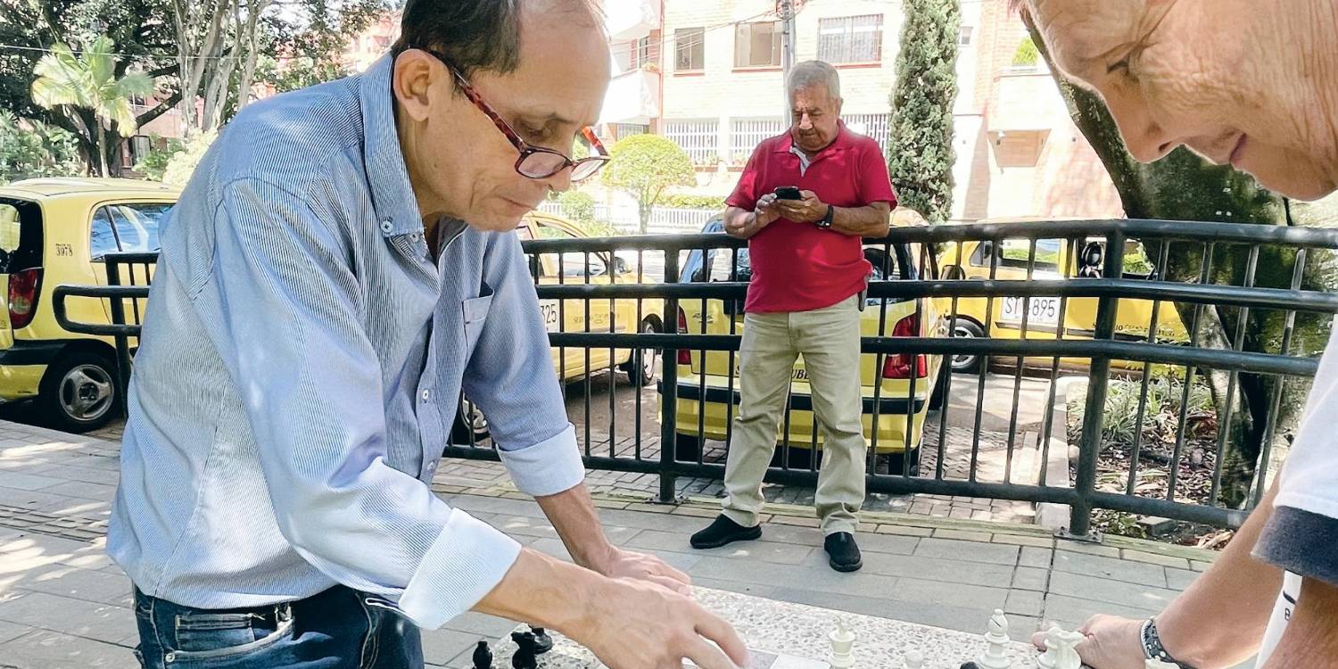 Jorge Meza Vásquez (izq.) y Rodrigo Álvarez Zapata (der.) engrosan el grupo de taxistas que juega ajedrez en acopio del barrio Laureles. FOTOS: JAIDER ESCOBAR B.