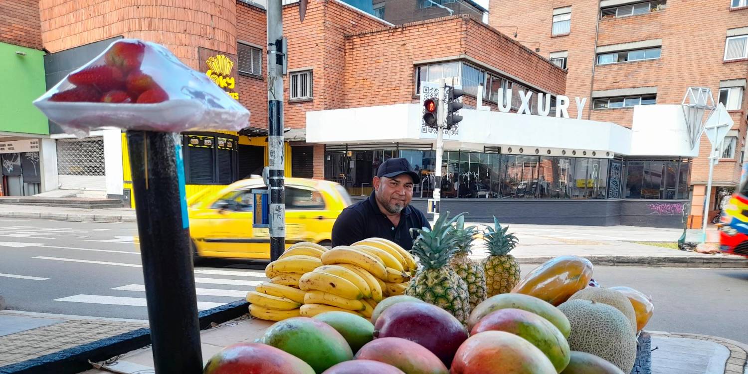 Alexánder Alvis ofrece sus coloridas frutas debajo del intercambio vial de la 80. Asegura que es un punto estratégico para su venta. /FOTO: DANIEL GONZALEZ JARAMILLO