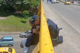 Este fue el momento en que el policía abrazó a la joven para evitar que se lanzara al vacío. /FOTO: VIDEO POLICÍA