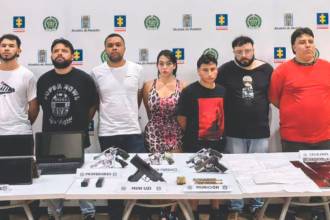 Los ocho hombres y la mujer que fueron capturados por la Policía durante la diligencia de allanamiento a la vivienda, junto a los elementos encontrados. FOTO: CORTESÍA