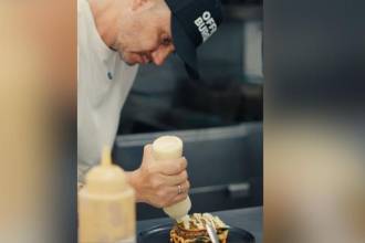 Él es Gustavo Calle preparando una de sus hamburguesas. / FOTO: CORTESÍA