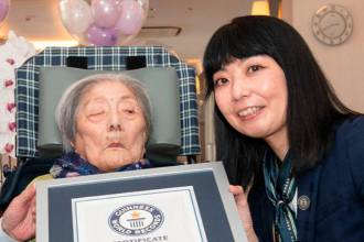 Tomiko Itooka (centro) con uno de sus hijos (izquierda) y la representante de los Récords Guinnes. / FOTO: RÉCORDS GUINESS