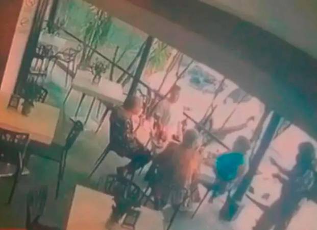 En esta imagen se ve cuando el sicario llegó a la mesa en la que estaban las víctimas. Esta es una captura del video de una de las cámaras de seguridad. /FOTO: CORTESÍA