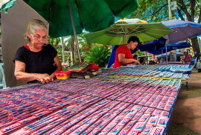 Venta de lotería a un costado de la iglesia La Candelaria en el Parque de Berrío. /FOTO: ANDRÉS CAMILO SUÁREZ. 