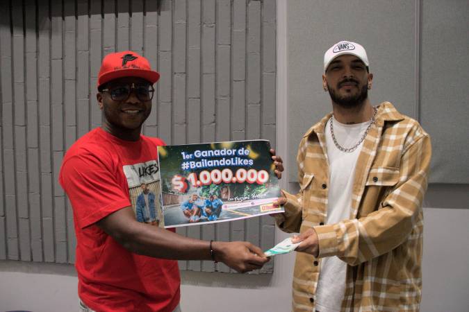 Momento en que Emilio, integrante de Fusión Perreo (izquierda), le entrega el premio Alexánder Jaramillo, uno de los ganadores. /FOTO: Q’HUBO MEDELLÍN. 