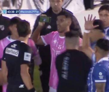 El momento exacto en el que el jugador le muestra el celular al árbitro por una jugada polémica. FOTO: CAPTURA DE PANTALLA TRANSMISIÓN LPD PLAY 