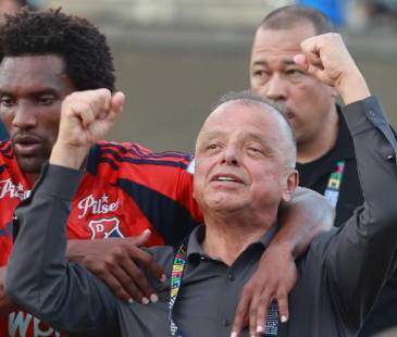 Didier Moreno (izq), jugador del DIM, tratando de sacar a Raúl Giraldo (der), máximo accionista del club, del campo del Atanasio Girardot. FOTO: MANUEL SALDARRIAGA 