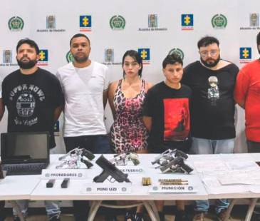 Los ocho hombres y la mujer que fueron capturados por la Policía durante la diligencia de allanamiento a la vivienda, junto a los elementos encontrados. FOTO: CORTESÍA