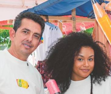 De izquierda a derecha: José; su nuera, Darlin; y su hijo, Deinner, quienes participan en la elaboración y comercialización del lápiz gigante, que también sirve de alcancía. FOTO: CORTESÍA LA PECO