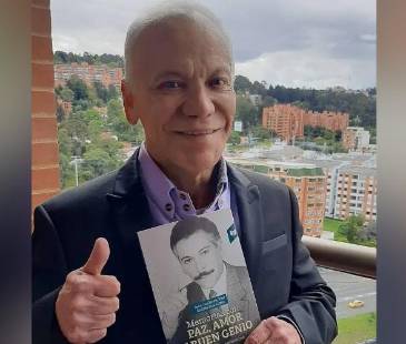 Juan Guillermo Ríos con el libro que escribió. FOTO: @OIRADIOTV 