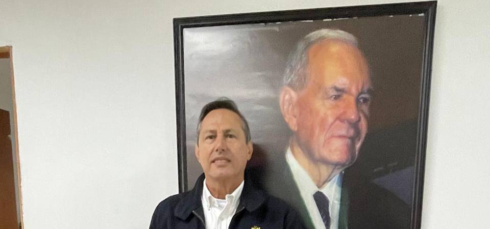 Raúl posa con orgullo posa al lado del cuadro de Jhon Restrepo, fundador de la compañía. FOTO: JAIDER ESCOBAR